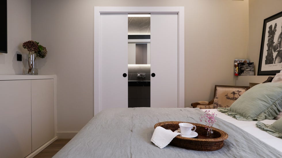 dormitorio con baño en suite y puertas correderas