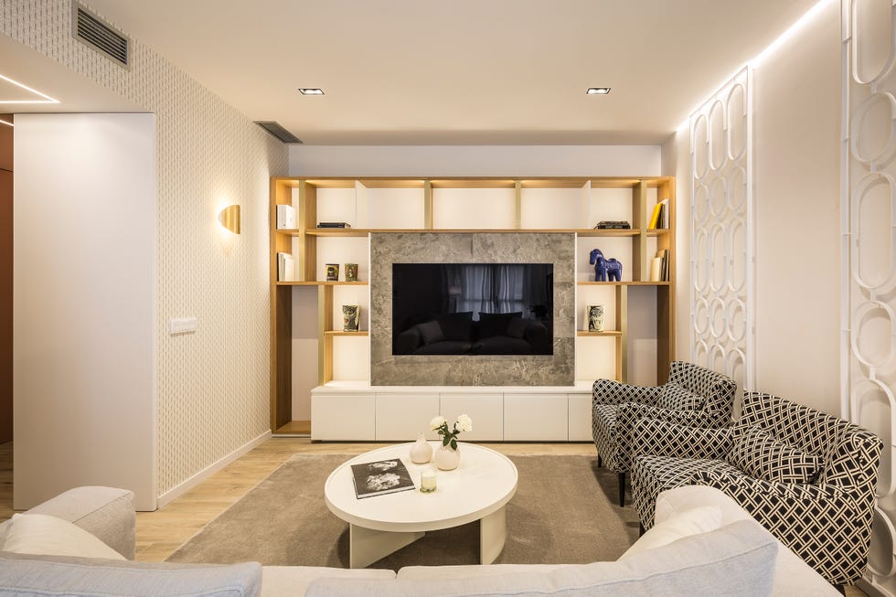 salón de diseño moderno con televisión empotrada y butacas con diseño geométrico
