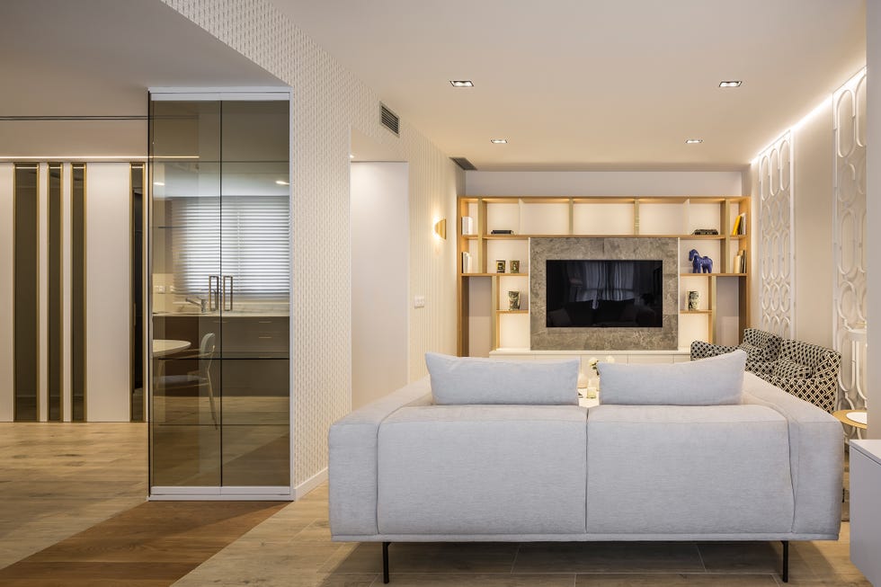 salón de diseño moderno con televisión empotrada y sofá beige