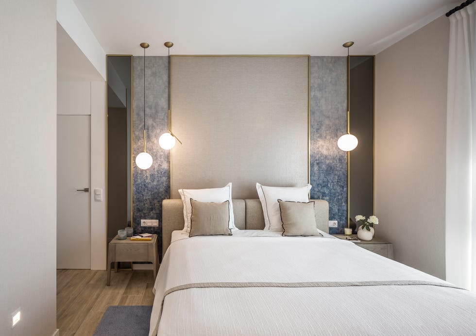 dormitorio de diseño elegante en color beige con cabecero diseñado a medida y lámparas suspendidas