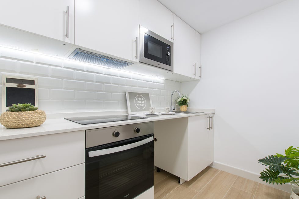 cocina blanca abierta de diseño moderno con frente de azulejos
