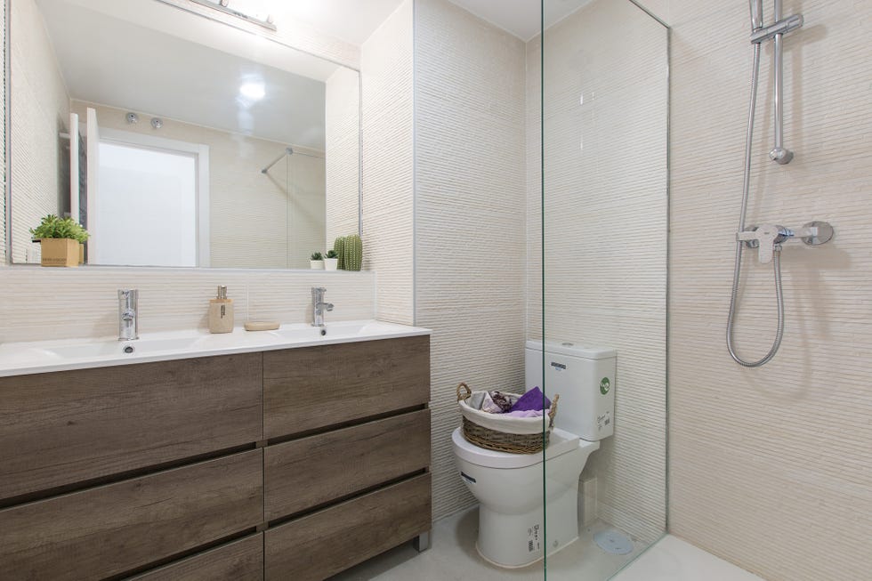 baño con ducha de obra y mueble con cajones de madera
