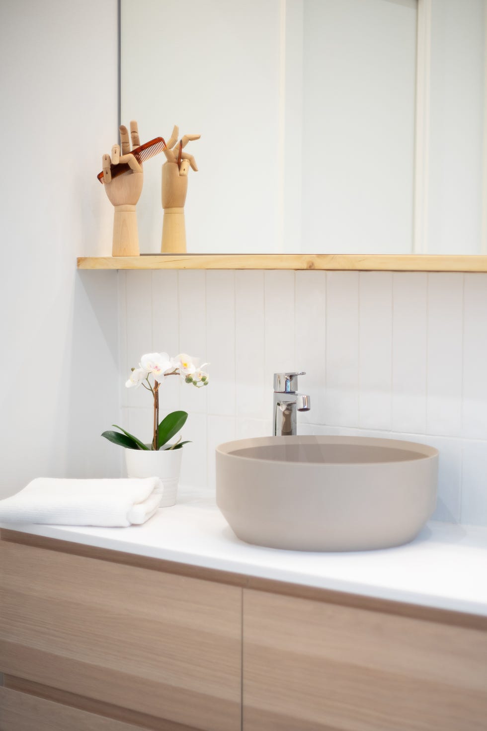 baño pequeño con muebles de madera y pila de cerámica beige redonda