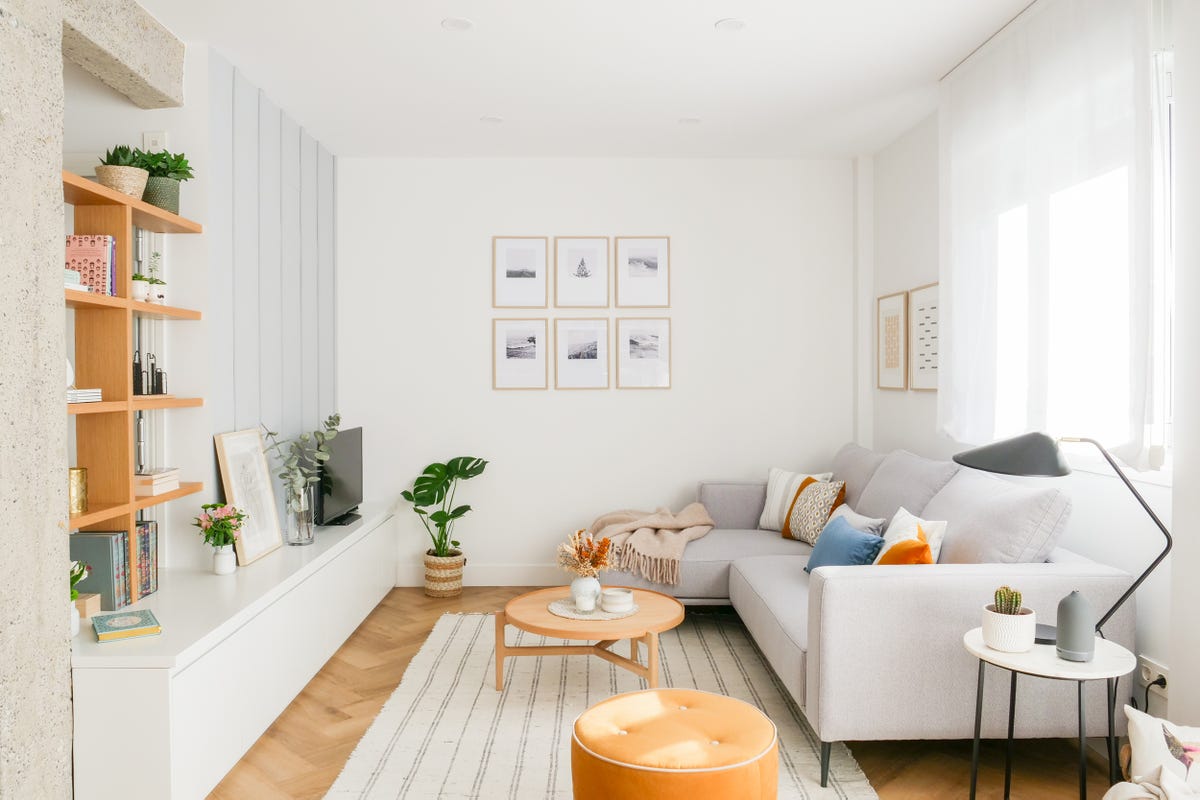 salón moderno con sofá con chaise longue gris, mesa de centro de madera y mueble de tv blanco