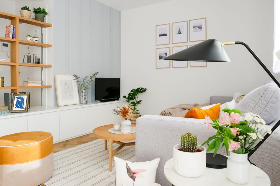 salón moderno con sofá con chaise longue gris, mesa de centro de madera y mueble de tv blanco