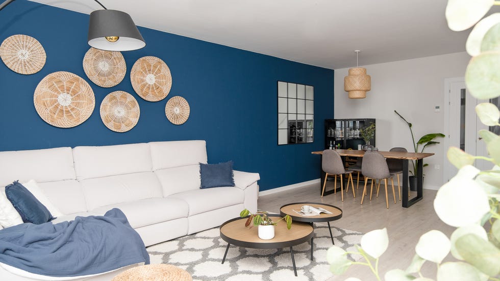 salón comedor con pared azul y sofá con chaise longue gris