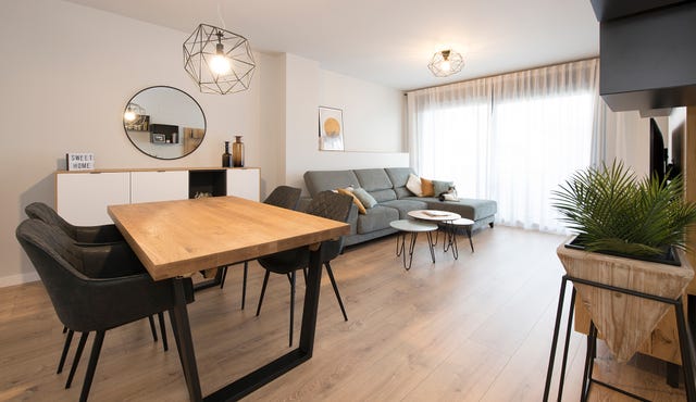 salón comedor decorado en tonos grises con mesa de comedor de madera