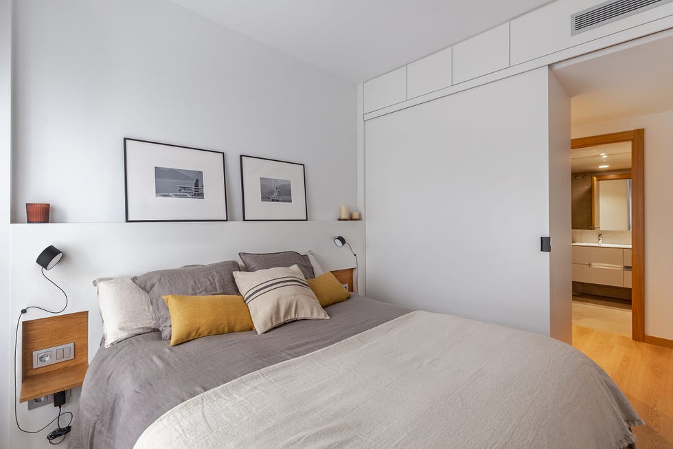 dormitorio con cabecero de obra y baño en suite
