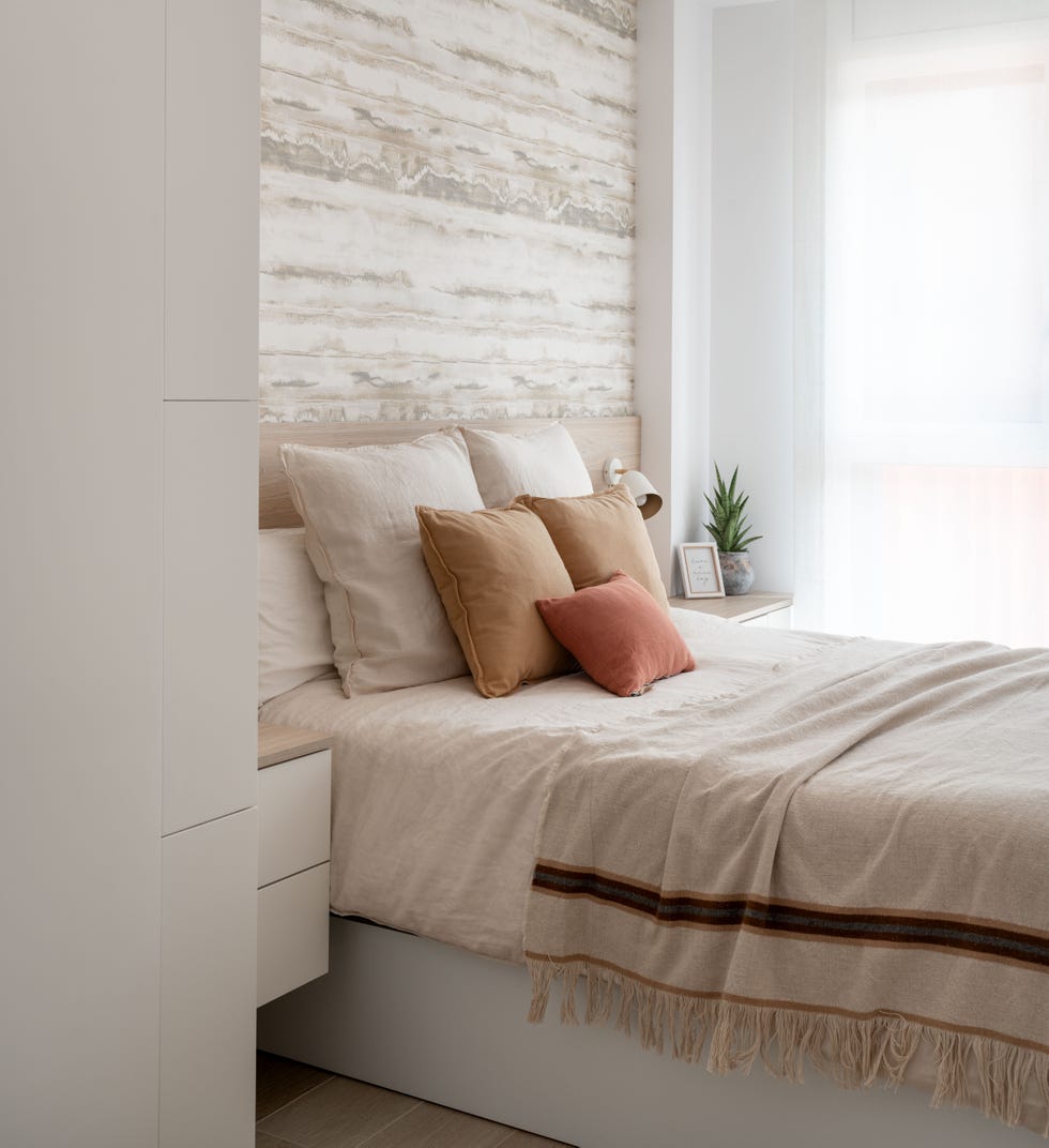 dormitorio con cabecero de madera y papel pintado efecto madera