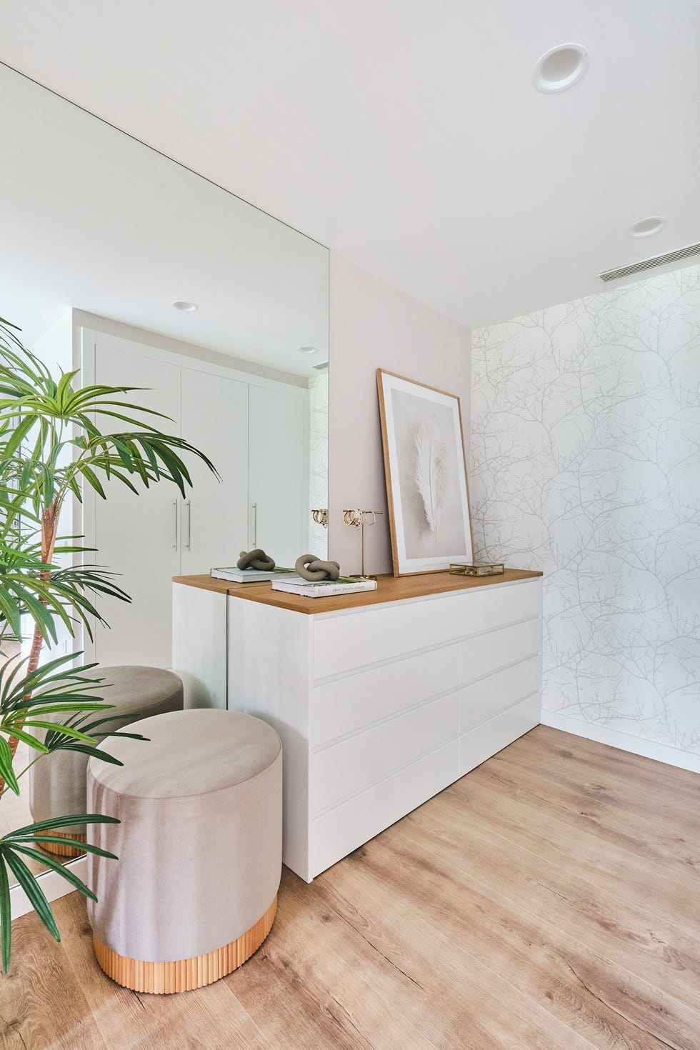 zona de vestidor con cómoda blanca y puf de terciopelo