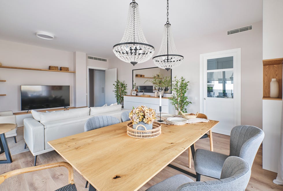 mesa de comedor de madera y metal, sillas tapizadas en gris y sillas de madera con asientos de cuerda