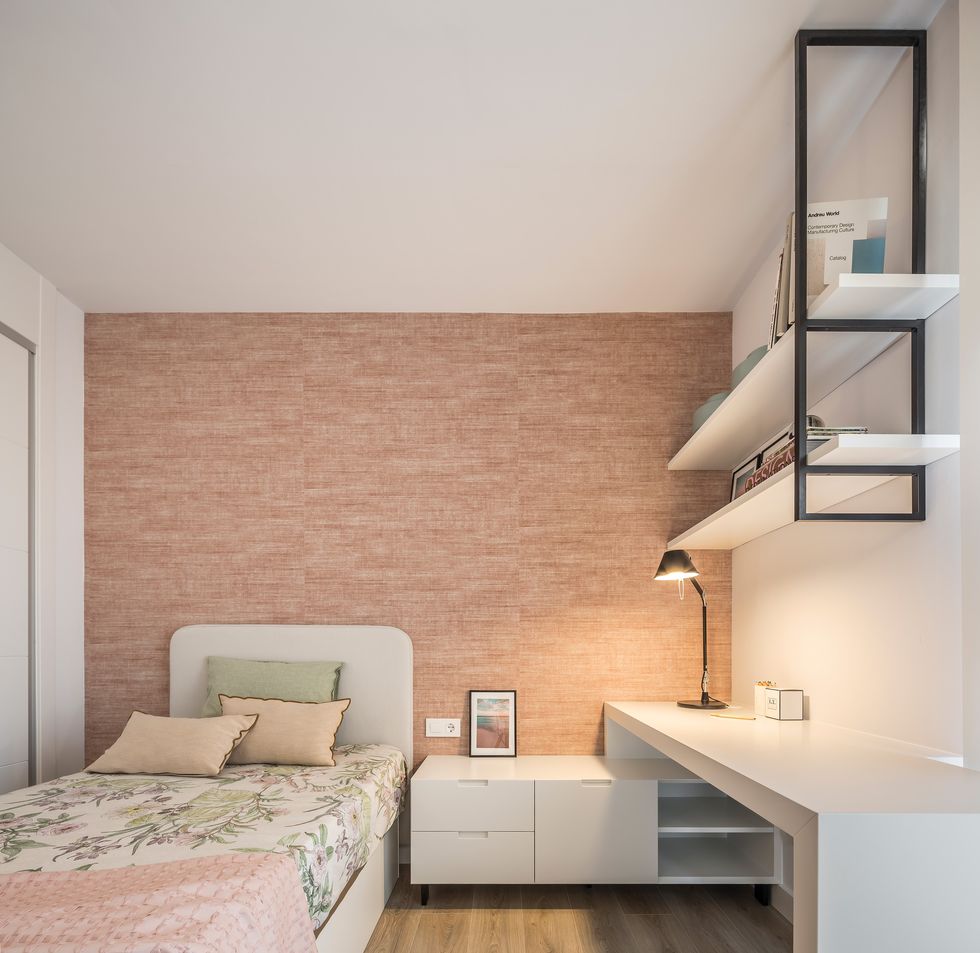 dormitorio con papel pintado rosa, cama individual y escritorio