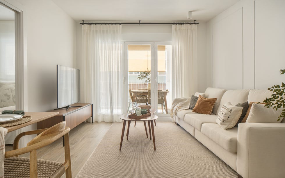sofá beige, mesas tipo nido y mueble de tv de madera