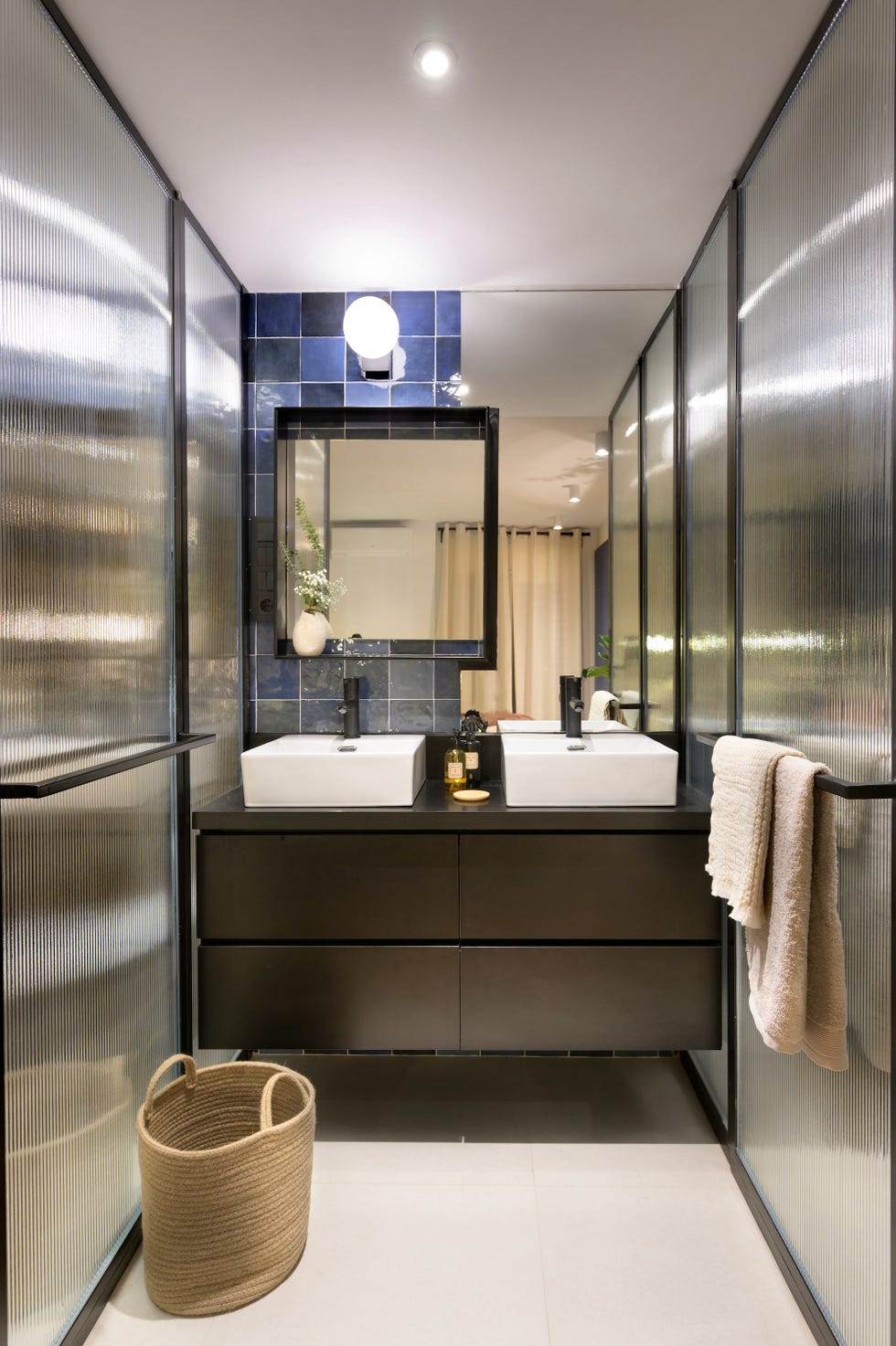 baño moderno con mueble suspendido negro y azulejos azules
