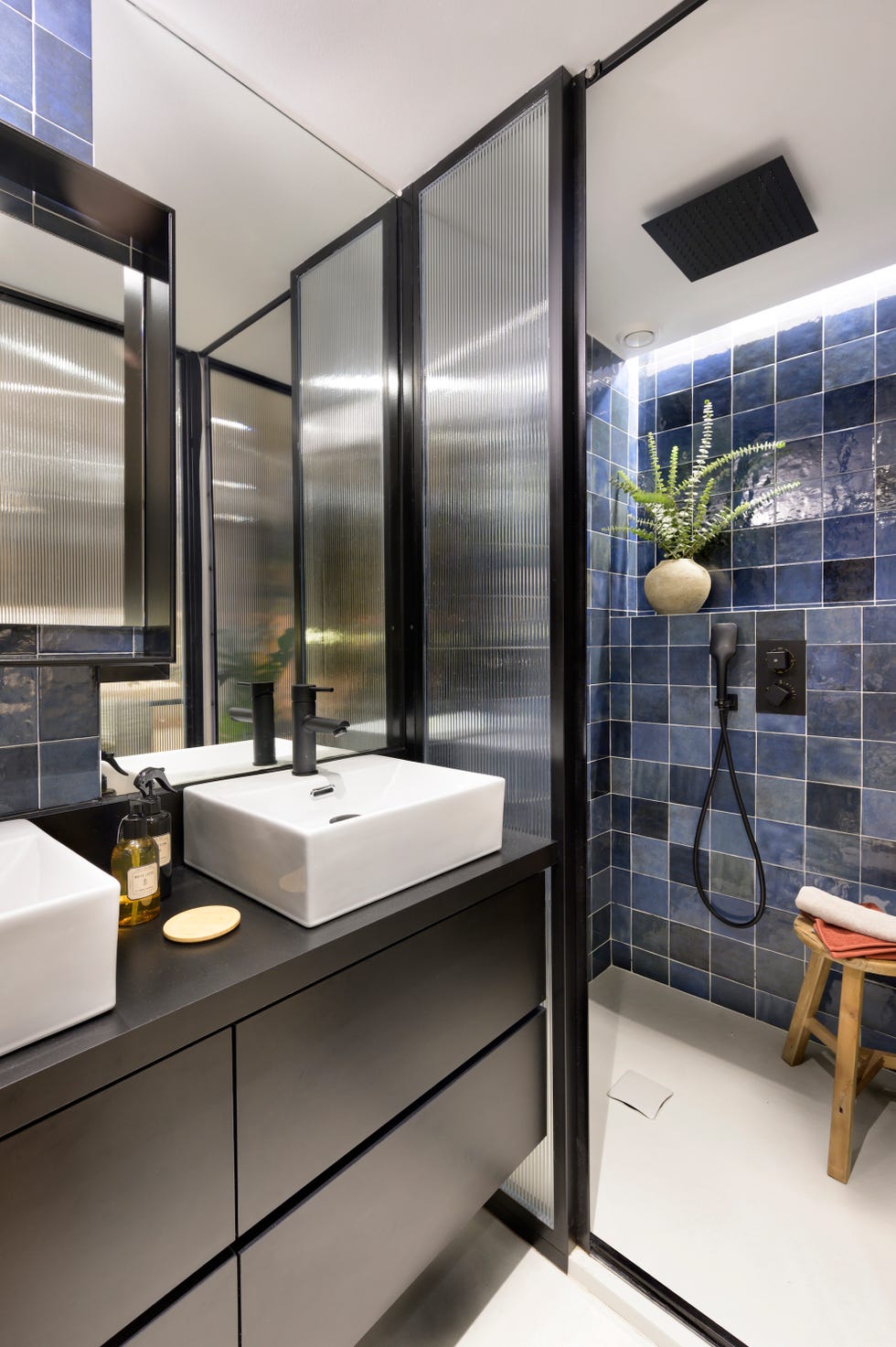 baño moderno con mueble suspendido negro y azulejos azules
