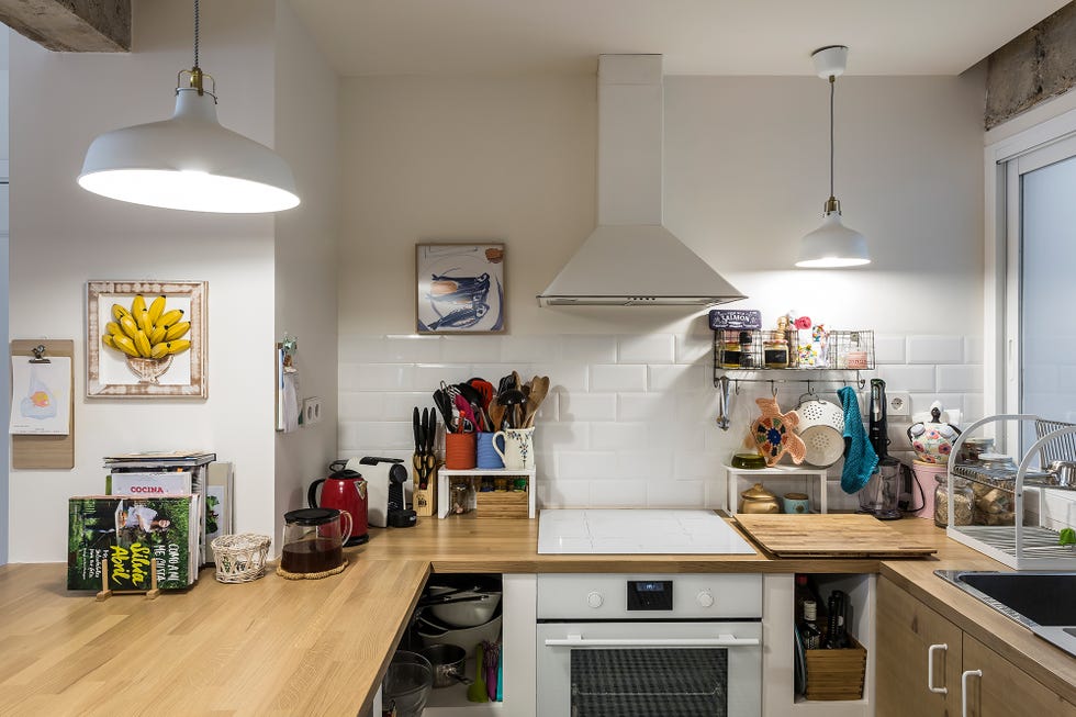cocina con encimera de madera y pared de azulejos blancos
