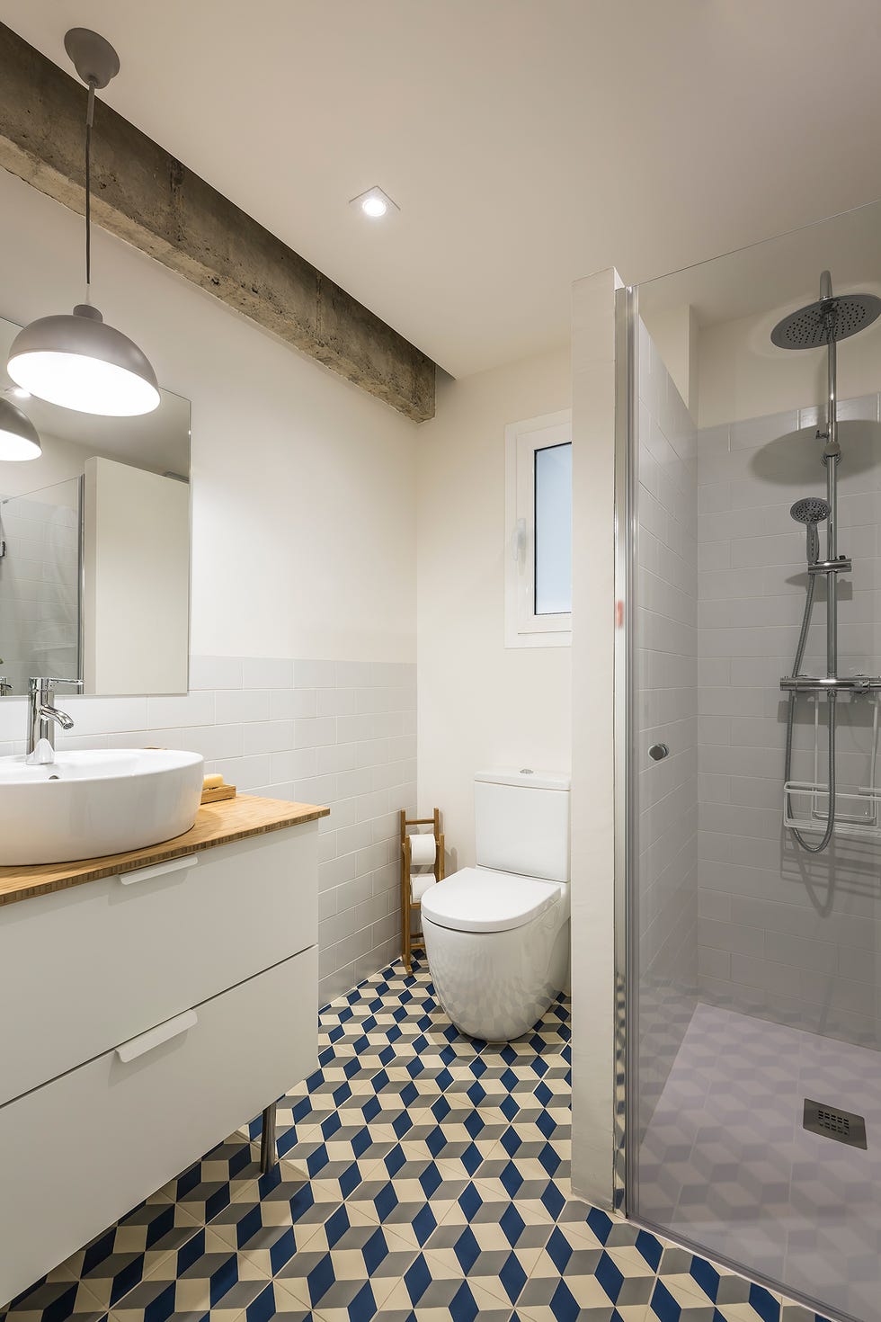 baño decorado en color blanco con ducha de obra y suelo de azulejos