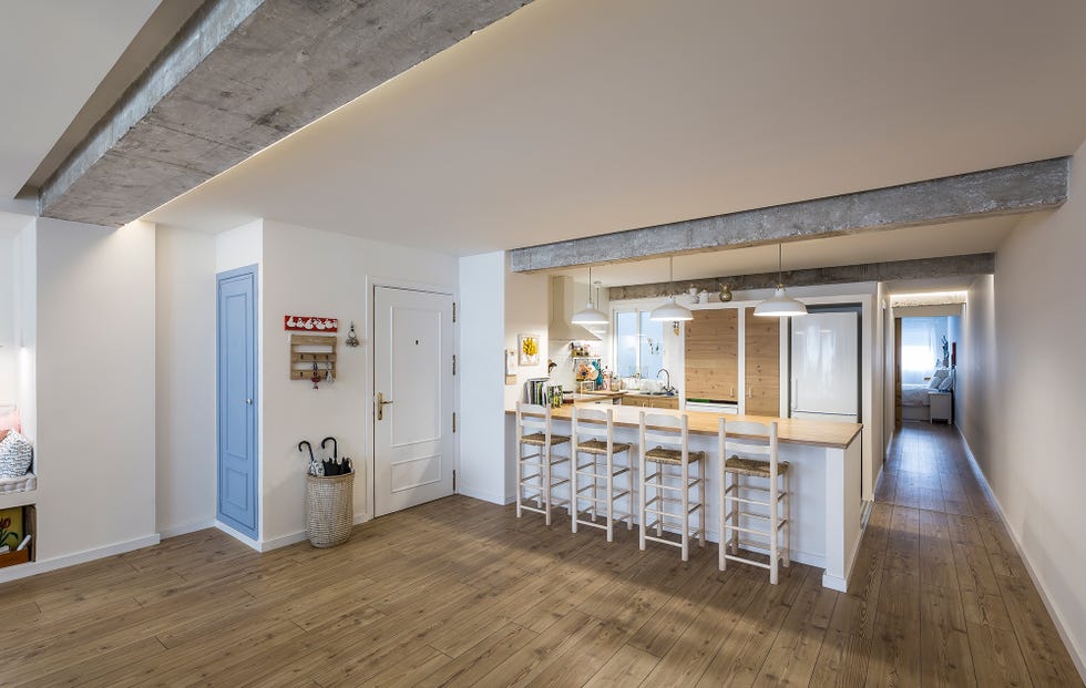 cocina con barra de desayunos decorada en blanco y abierta al salón comedor