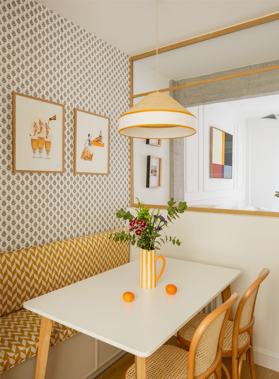 mesa de comedor con sillas de madera y rejilla y bancada a medida con tapizado en tonos mostaza