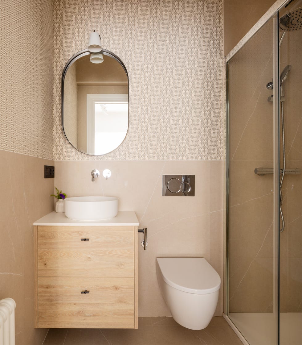 mueble de lavabo de madera volado y pared con papel pintado con motivos geométricos