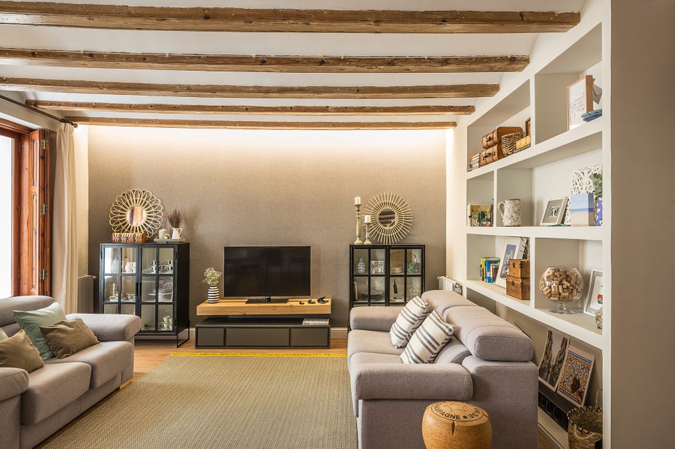 salón con dos sofás grises y vigas de madera vistas