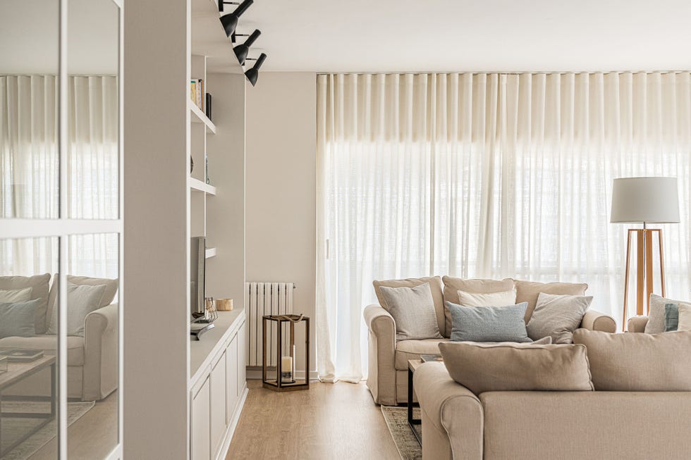 salón natural con librería blanca a medida y sofás beige