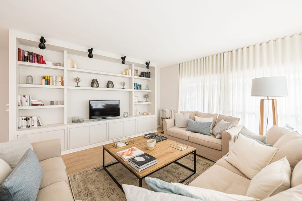 salón natural con librería blanca a medida y sofás beige