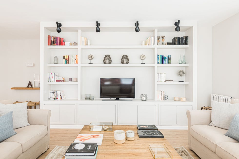 salón natural con librería blanca a medida y sofás beige