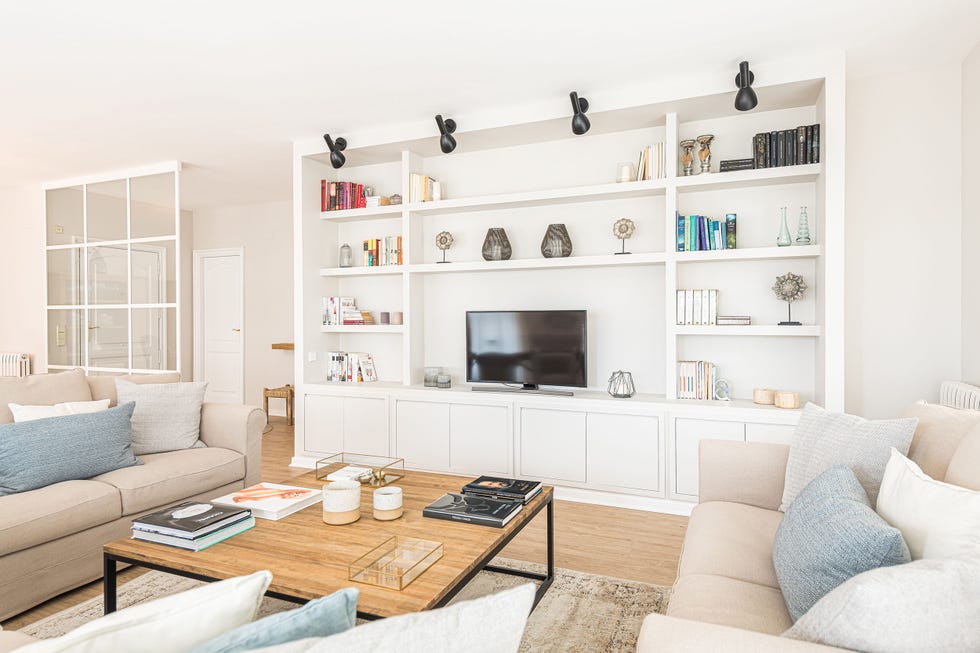 salón natural con librería blanca a medida y sofás beige