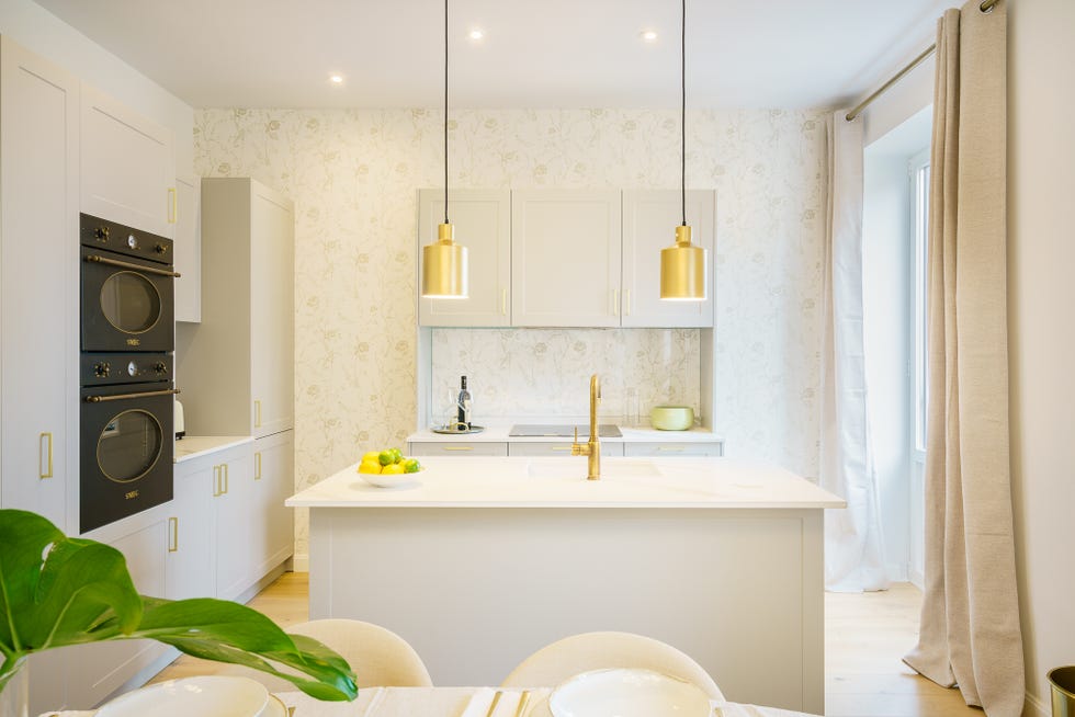 cocina gris abierta con isla central y detalles dorados