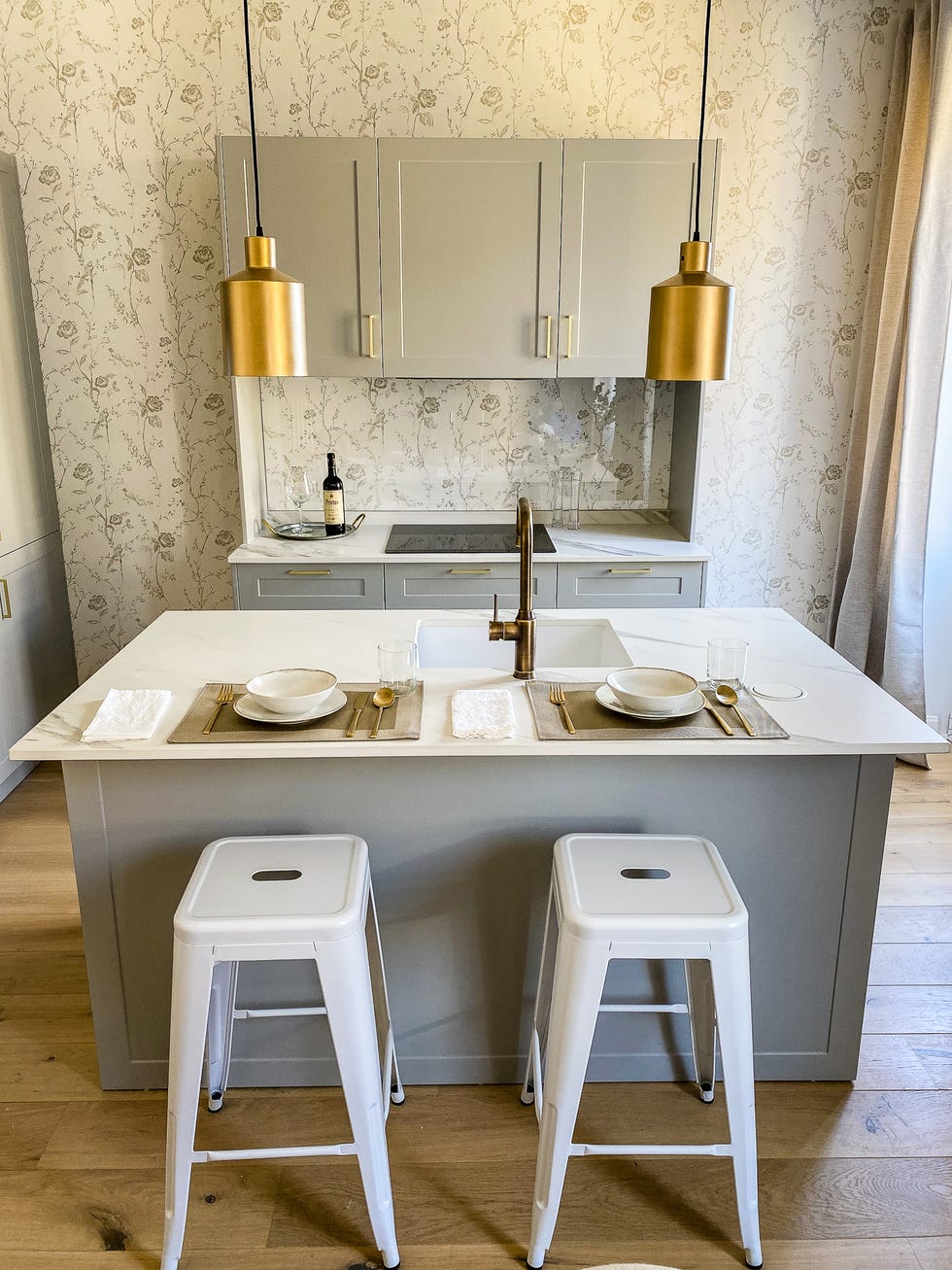 cocina gris abierta con isla central y detalles dorados