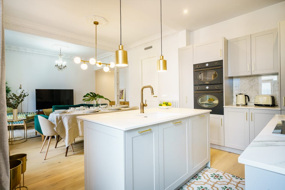 cocina gris abierta con isla central y detalles dorados