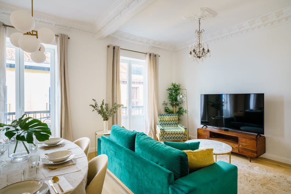 salón señorial con sofá de terciopelo verde y mesa de centro de mármol
