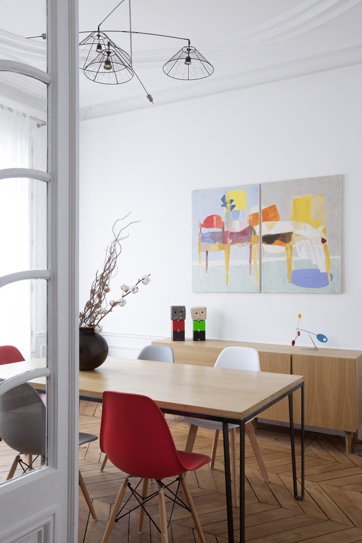 comedor moderno con mesa de madera y sillas nórdicas de colores