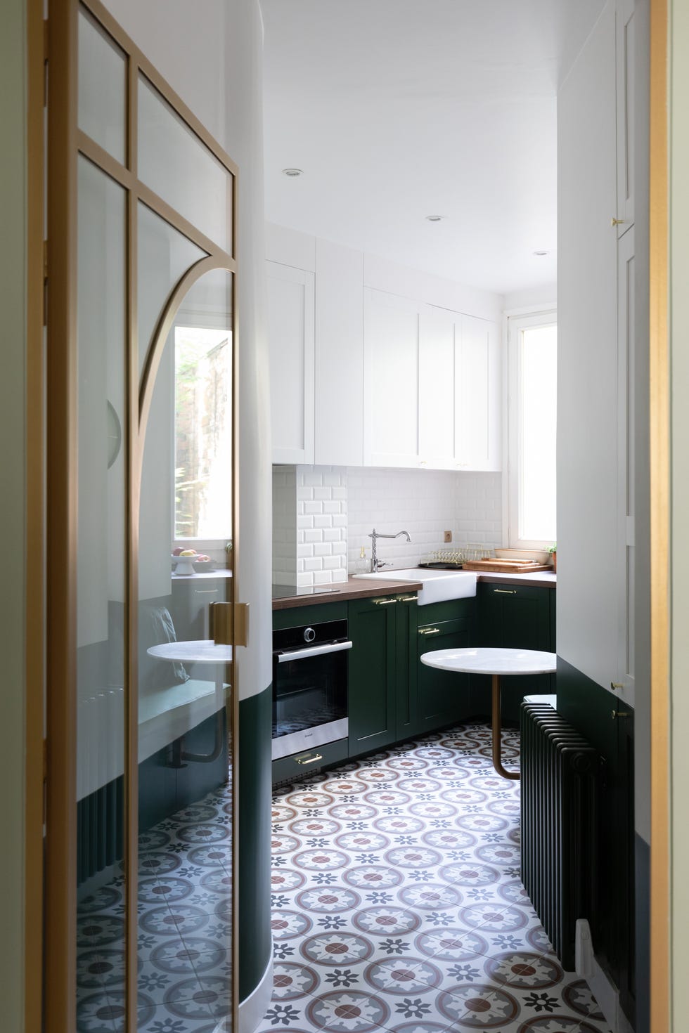 cocina de estilo vintage con suelo de baldosas geométricas y armarios de color verde intenso