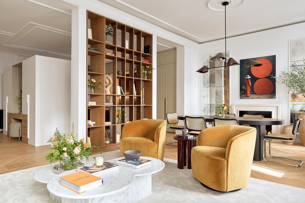 salón comedor con mesa de centro de mármol y butacas de terciopelo mostaza