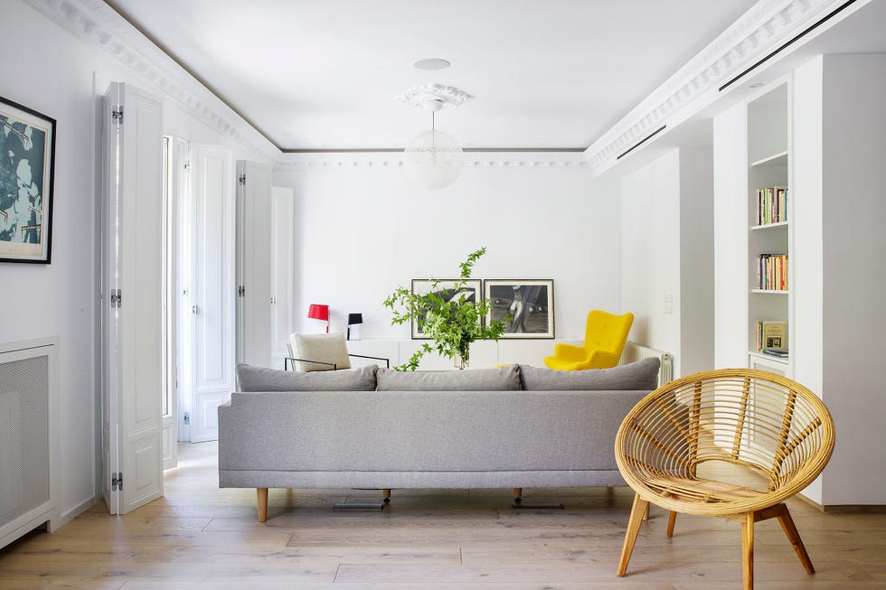 salón señorial con sofá gris y butaca de ratán