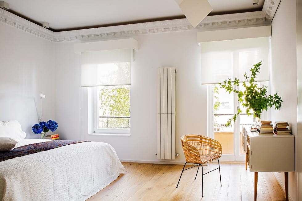 dormitorio blanco con molduras decorativas y escritorio de madera
