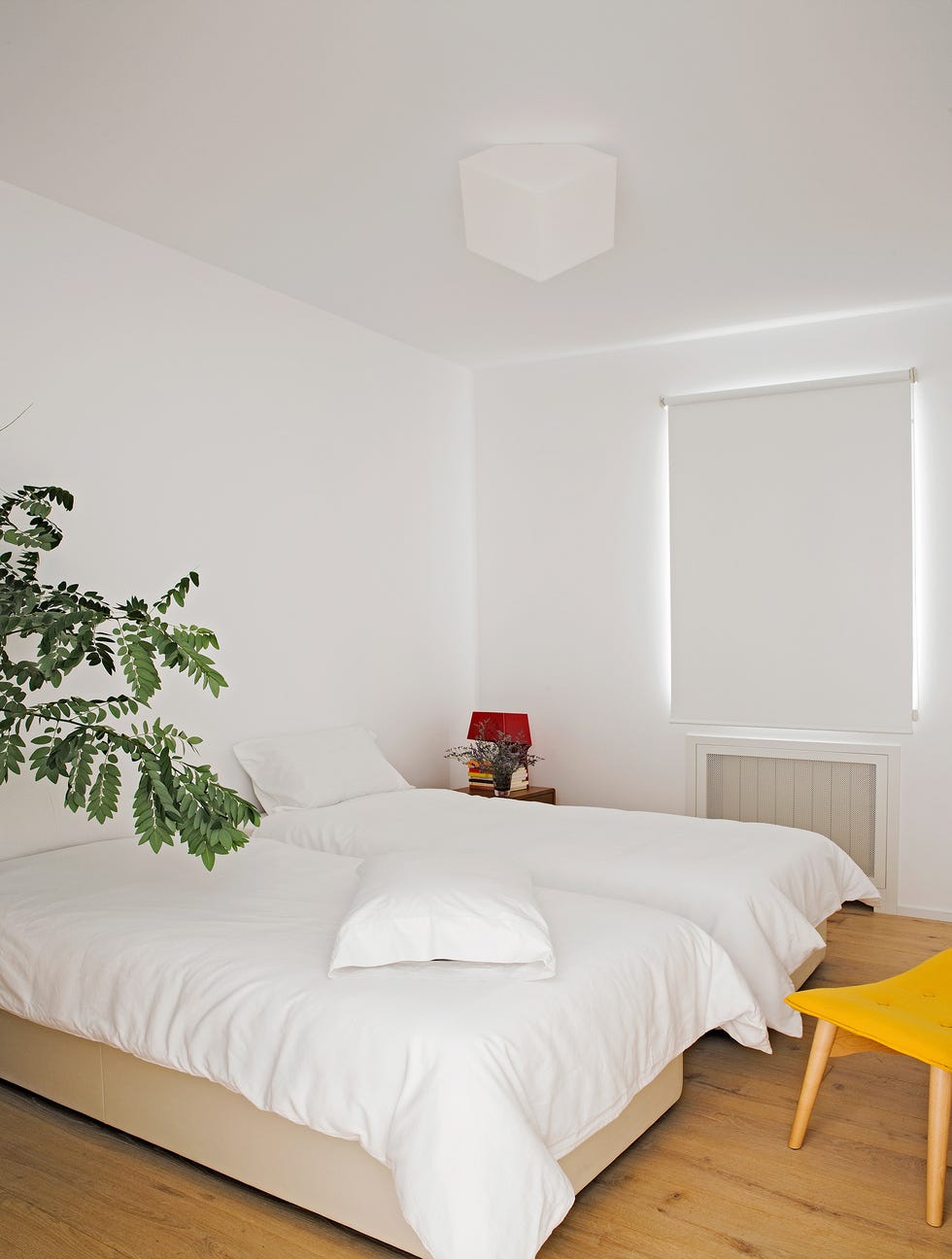 dormitorio decorado en blanco con dos camas individuales