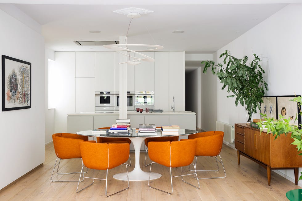 comedor de diseño contemporáneo con sillas tapizadas en color naranja