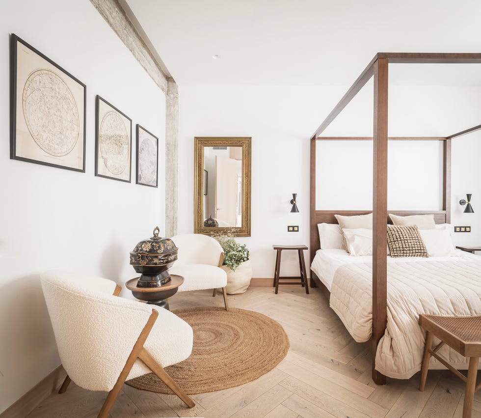 cama con dosel de madera y rincón de lectura con dos butacas