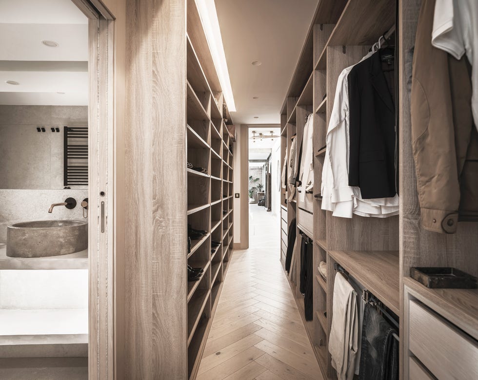 vestidor en suite con armarios de madera junto al baño