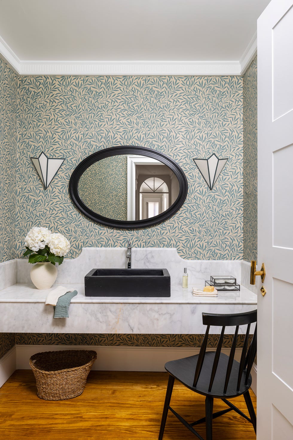baño con mueble de mármol y papel pintado botánico