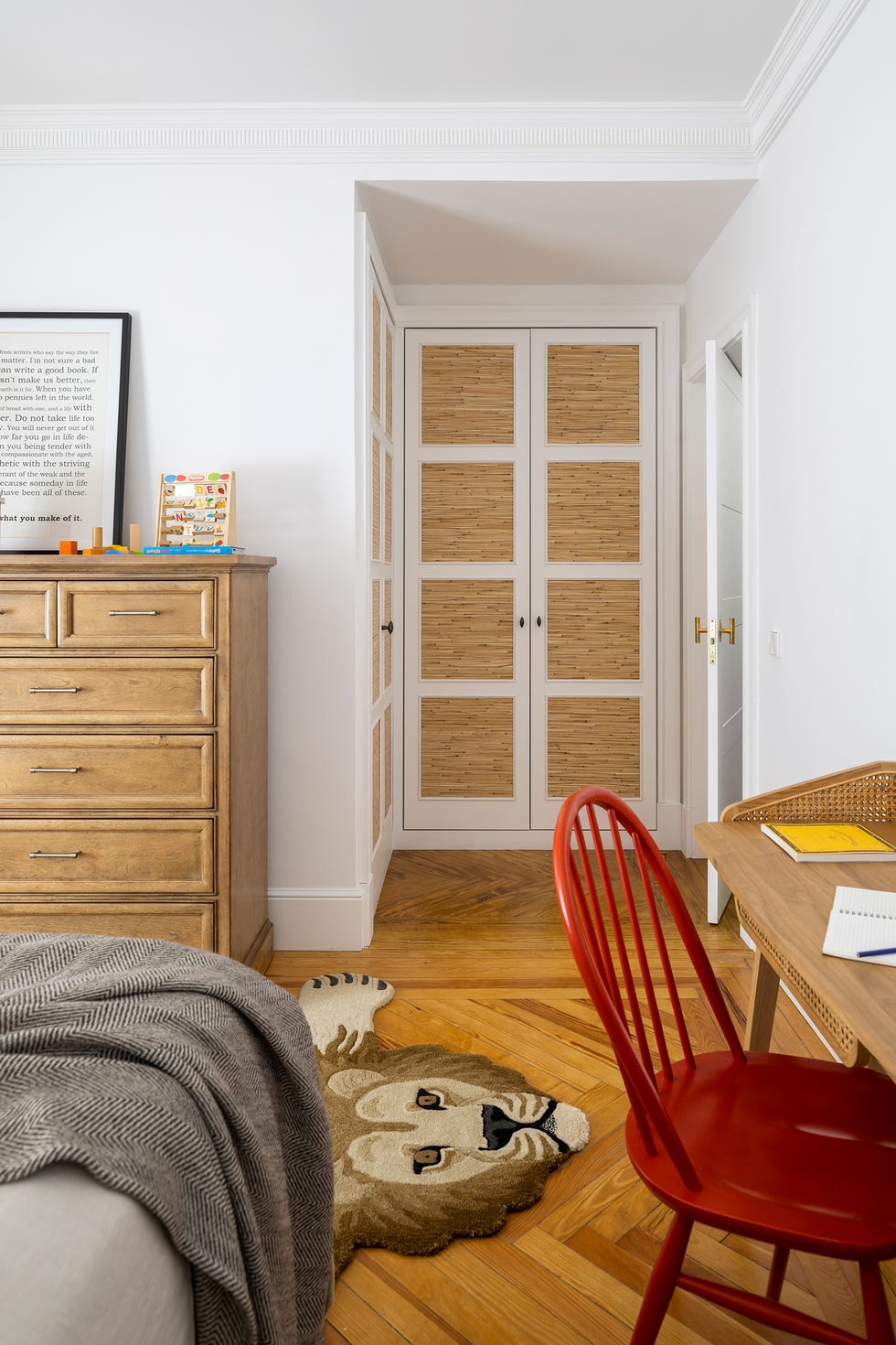 habitación infantil con cómoda clásica de madera y armario con puertas de rejilla