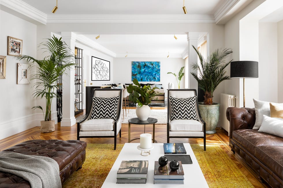 salón de diseño con plantas de interior, sofá chester y puf a juego