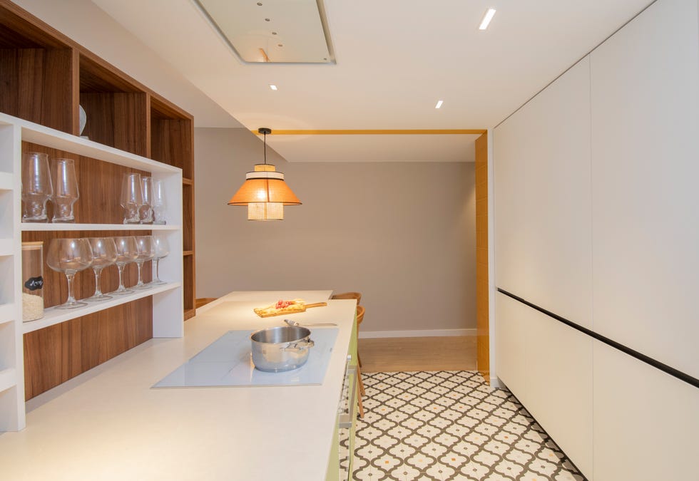 cocina moderna con isla central, armarios blancos y suelo con baldosa geométrica