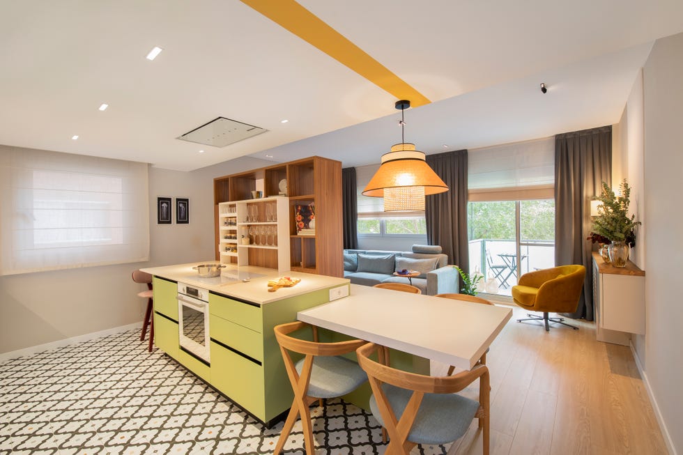 cocina abierta con isla central de color verde y suelo de baldosa geométrica