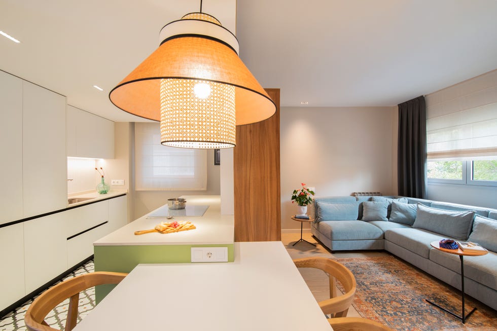 cocina con office abierta al salón decorada con color y estantería de nogal como divisor de ambientes