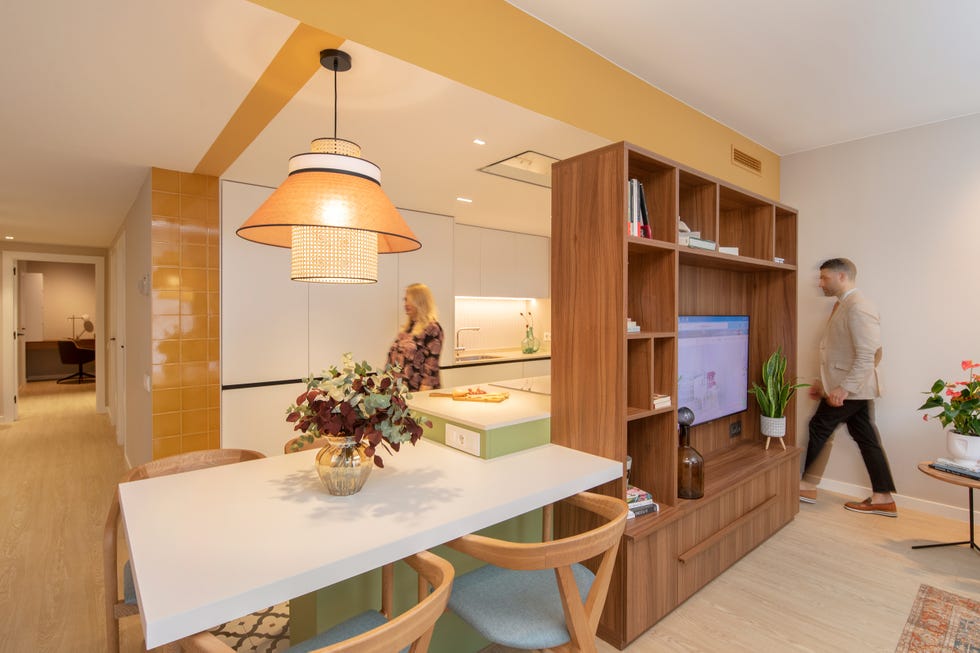 cocina con office abierta al salón decorada con color y estantería de nogal como divisor de ambientes