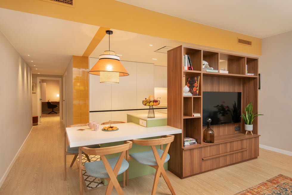cocina con office abierta al salón decorada con color y estantería de nogal como divisor de ambientes